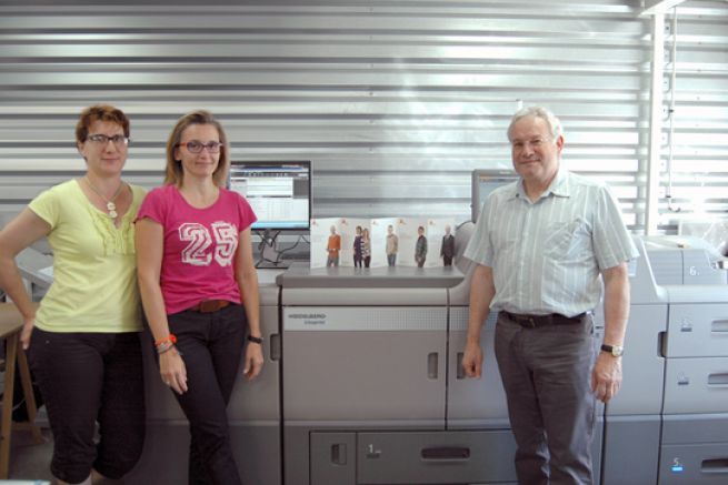 Les deux opratrices PAO et Yannick Garet le directeur de l'imprimeur prennent la pose devant la Linoprint d'Heidelberg.